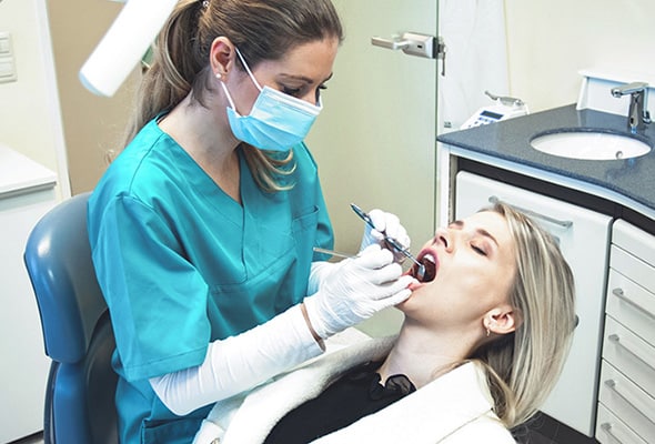 Zahnärztin Carolin Tent und eine junge Patientin bei der Kontrolle der Zähne