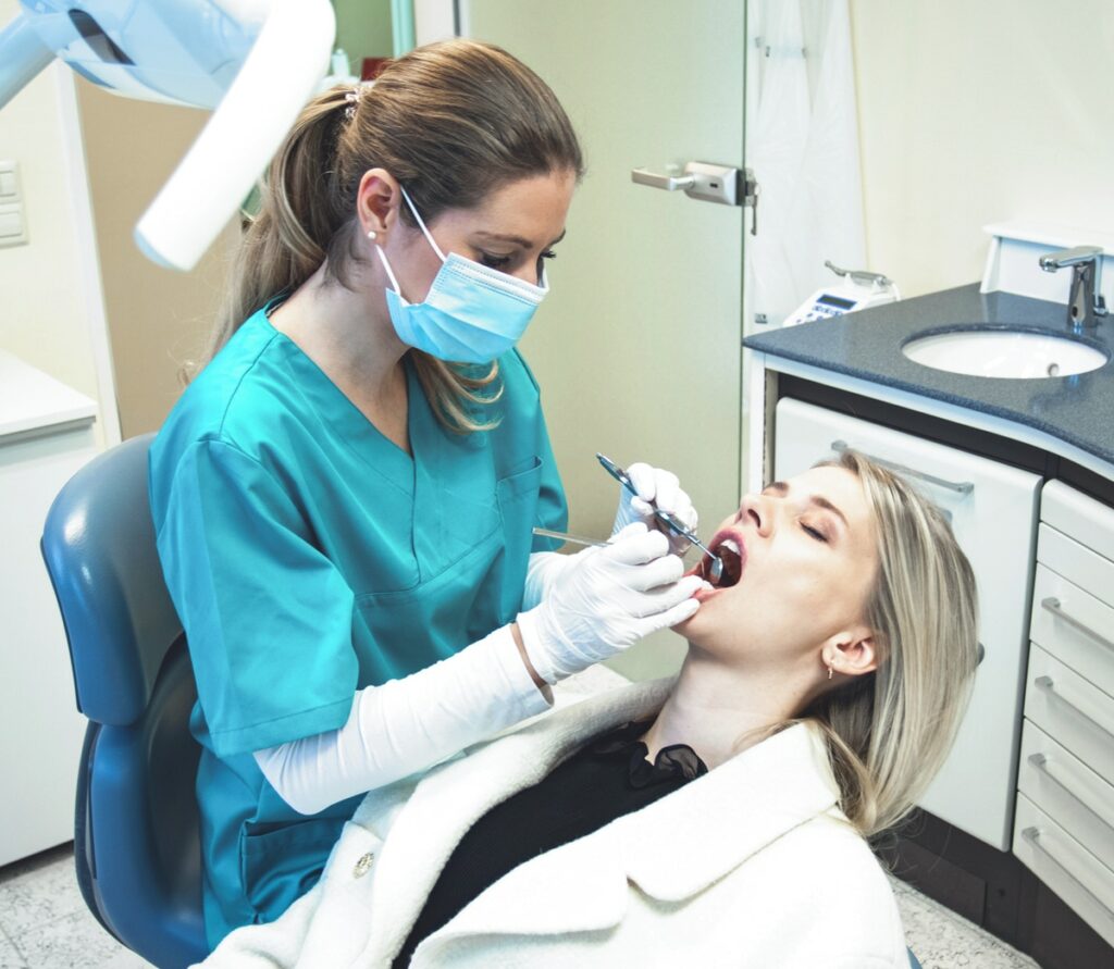 Zahnärztin Carolin Tent und eine junge Patientin bei der Kontrolle der Zähne